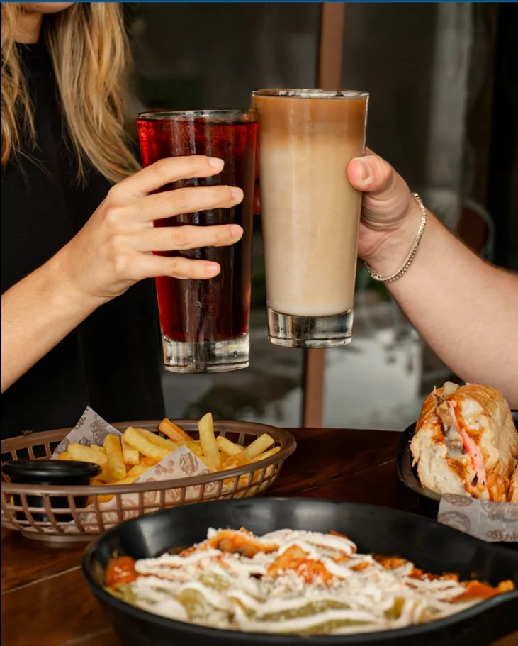 Dos personas brindan con bebidas en una mesa de Béjar